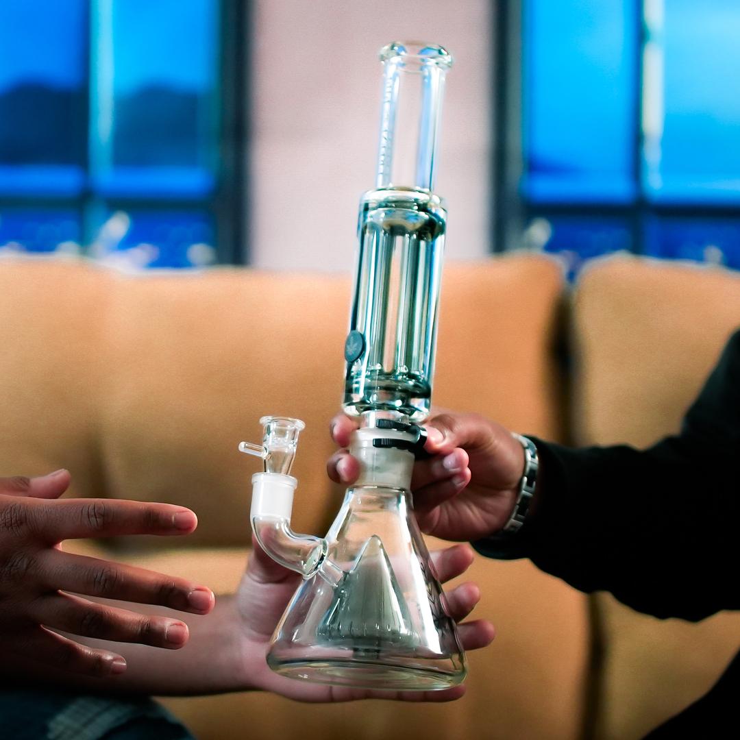 User holding assembled Freeze Pipe Bong Pro with frozen coil ready for use on table