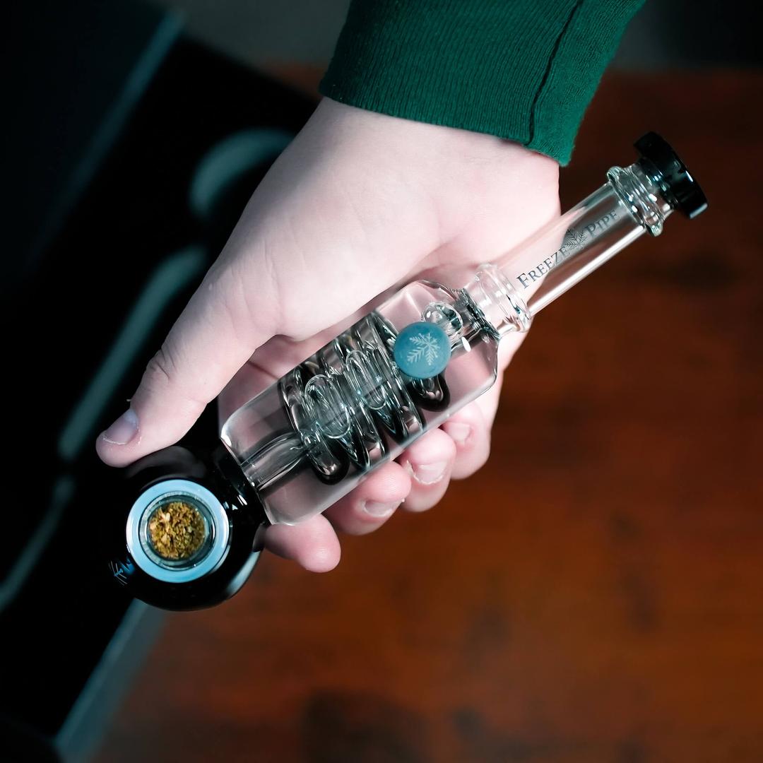 Person holding Freeze Pipe with frozen glycerin coil for smooth, cool smoke”