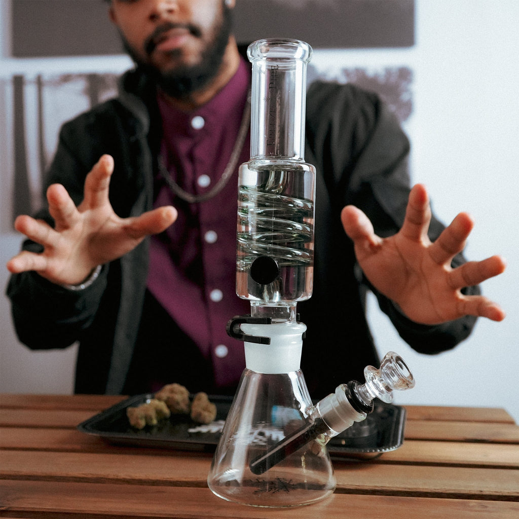 Person showcasing Freeze Pipe Beaker Bong with detachable glycerin coil and sturdy glass base for smooth hits
